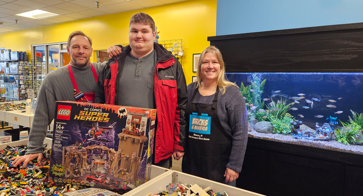 Nolan with Bricks and Minifigs owners in Rhode Island, celebrating supported employment for individuals with disabilities.